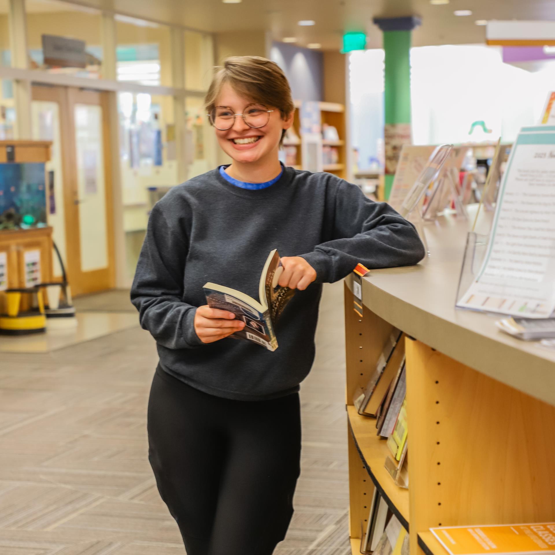 Adult With a Book Smiling