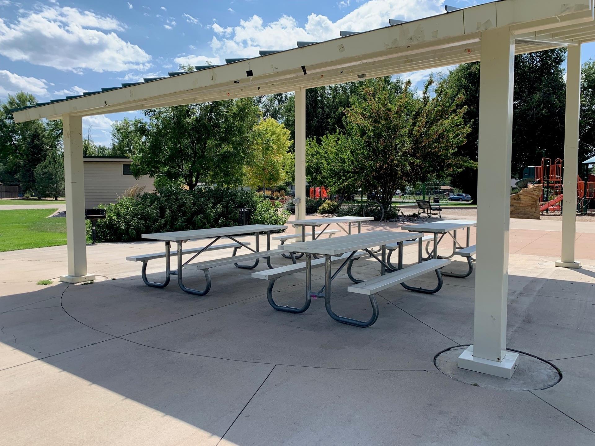 Picture of Duncan Park pavilion with trees, bushes and playground around the pavilion.