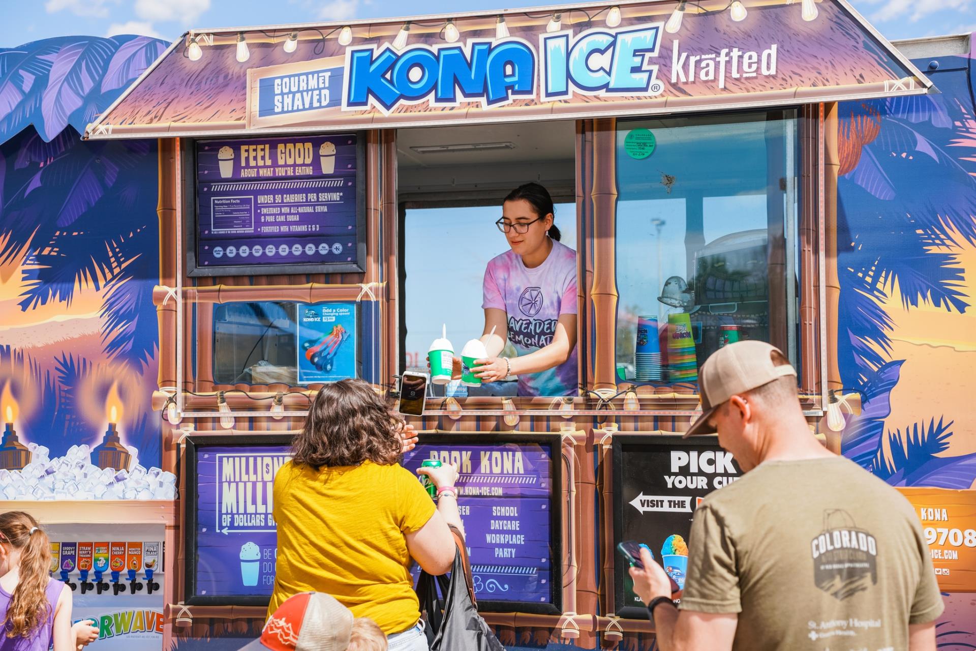 Kona Ice worker handing out shaved ice to customers