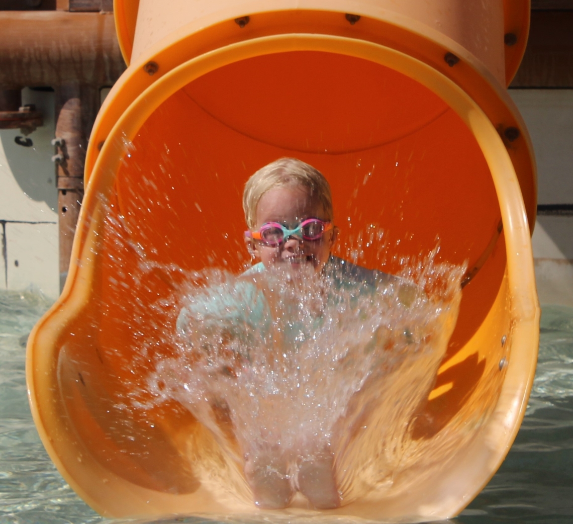 Small Kid Going Down Orange Slide