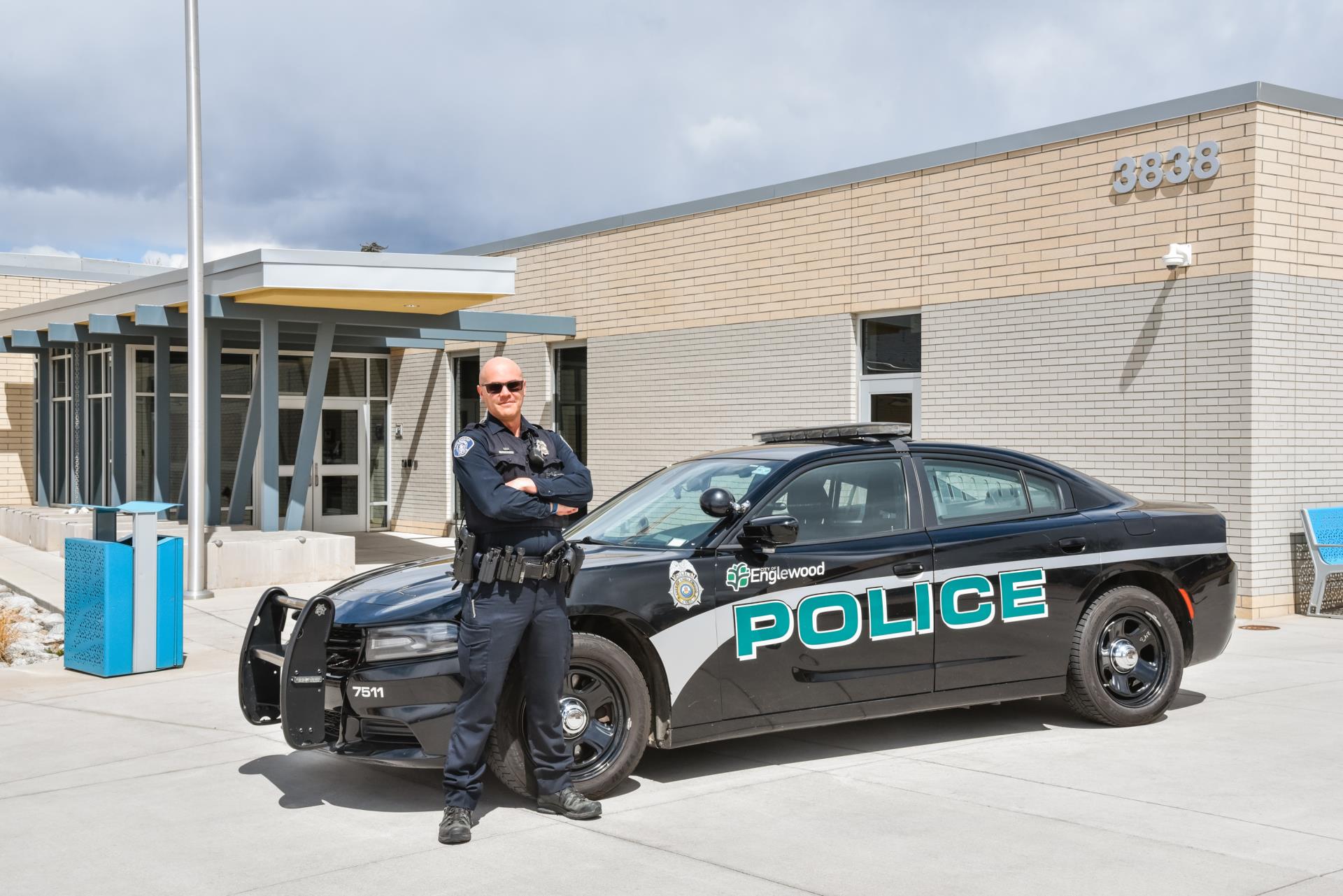 Police Officer in front of a police car outside the police department