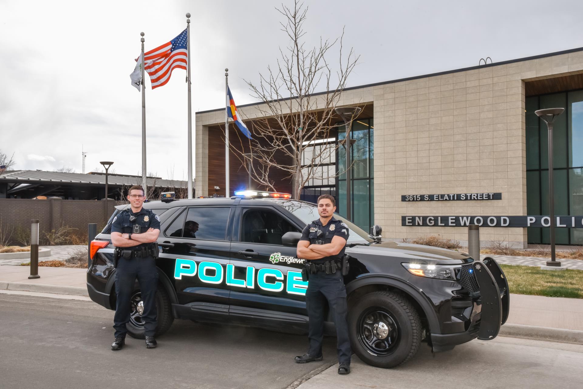 Two police officers in front of a police car